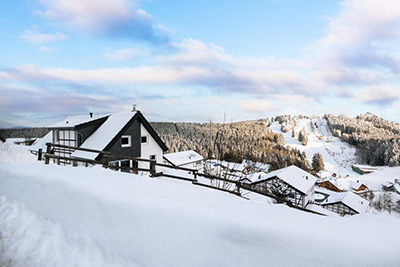 Ferienpark Landal Winterberg in einer verschneiten Landschaft mit Skipiste