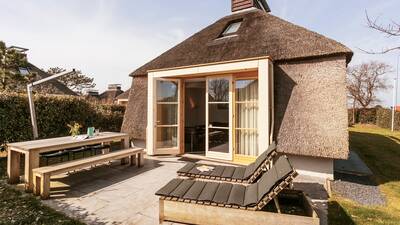 Garten eines Ferienhauses mit Reetdach im Ferienpark Dutchen Park Duynvallei