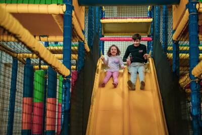 Zwei Kinder auf der Rutsche des Indoor-Spielplatzes im Ferienpark Europarcs de Achterhoek