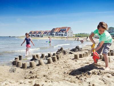 Kinder spielen am Strand des Ferienparks Landal Port Greve