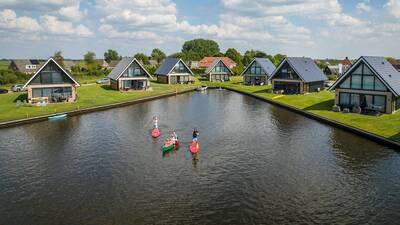 Luftaufnahme von Menschen in Kanus und Ferienhäusern im Landal Waterpark De Alde Feanen