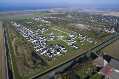Luftaufnahme der Ferienhäuser im Roompot Ferienpark Callassande und die Nordsee am Horizont