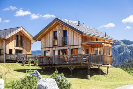 Freistehende Ferienhäuser im Alps Resorts Almdorf Hohentauern, mit Bergen im Hintergrund