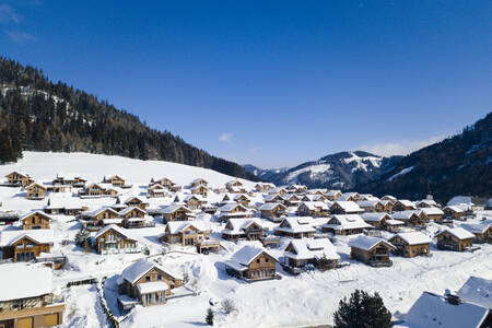 Luftaufnahme freistehender Ferienhäuser im Schnee im Alps Resorts Almdorf Hohentauern