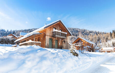 Freistehende Holzchalet im Schnee im Alps Resorts Almdorf Stadl Resort