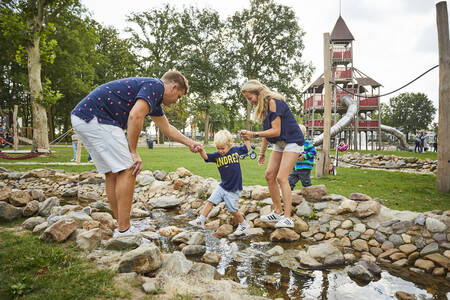 Kinder spielen am Spielfluss auf dem Spielplatz von Buitenhof de Leistert