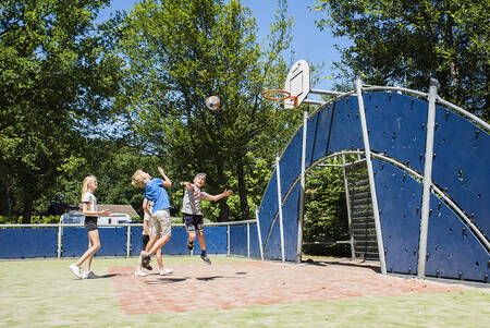 Kinder spielen Basketball auf dem Spielfeld von Camping Vreehorst