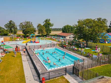 Menschen schwimmen im Außenpool des Ferienparks Camping Zonneweelde