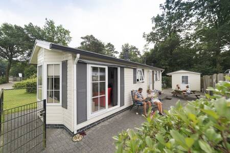 Menschen im Garten eines Chalets im Ferienpark Camping de Noetselerberg