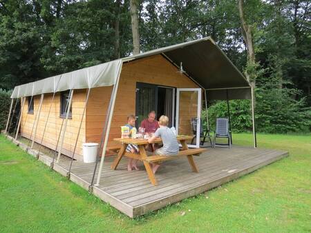 Menschen auf der Veranda einer Safarilodge im Ferienpark Camping de Noetselerberg