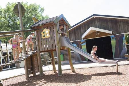 Kinder spielen auf einem Spielplatz im Ferienpark Camping de Noetselerberg