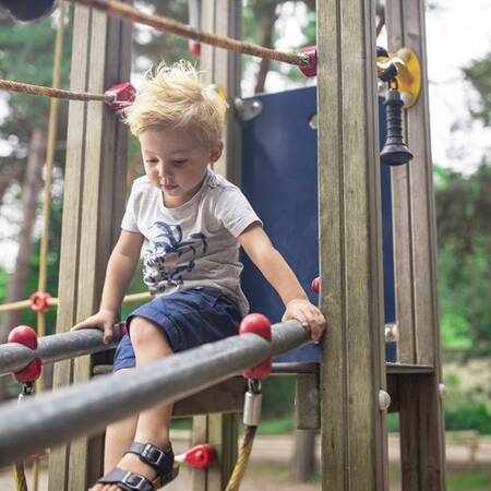 Ein Kind spielt auf einem Spielplatz im Center Parcs Les Ardennes