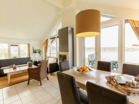 Wohnzimmer mit Essbereich und Kamin eines Ferienhauses im Center Parcs Parc Sandur