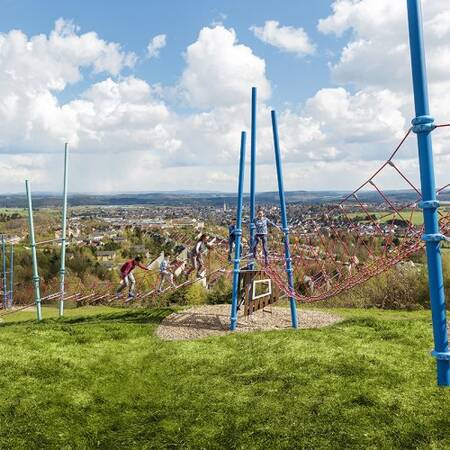 Kinder spielen auf einem Spielplatz im Freien des Center Parcs Park Hochsauerland