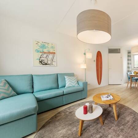 Wohnzimmer mit Sofa und Essbereich in einem Ferienhaus im Center Parcs Park Zandvoort