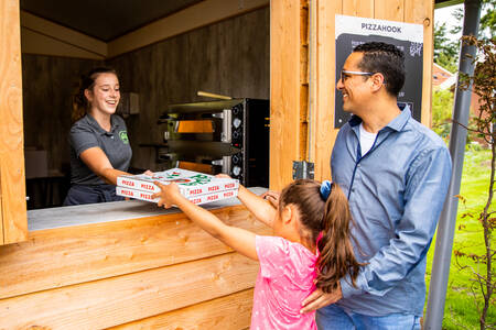 Vater und Tochter kaufen Pizza am Pizzahook auf dem Campingplatz De Witte Berg