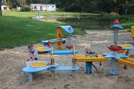 Kinder spielen auf dem Wasserspielplatz auf dem Campingplatz De Witte Berg