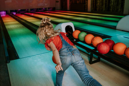 Mädchen beim Bowling auf der Bowlingbahn des Ferienparks Dierenbos