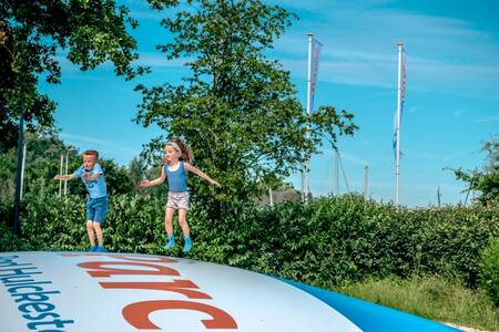 Kinder springen auf dem Lufttrampolin auf einem Spielplatz im Ferienpark EuroParcs Bad Hulckesteijn