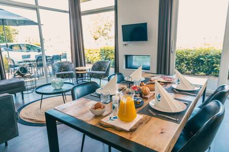 Gedeckter Tisch im Wohnzimmer eines Ferienhauses im Ferienpark EuroParcs De Biesbosch