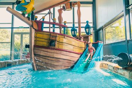 Kind auf der Rutsche im Planschbecken des Ferienparks EuroParcs De Biesbosch