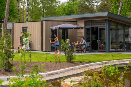 Familie im Garten eines Chalets im Ferienpark EuroParcs De Hooge Veluwe