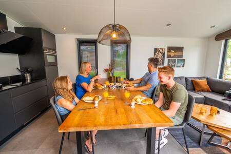 Menschen am Küchentisch in einem Ferienhaus im Ferienpark EuroParcs De Hooge Veluwe