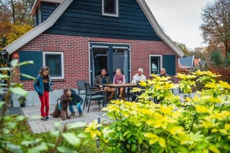 Menschen im Garten eines freistehenden Ferienhauses im Ferienpark EuroParcs De Hooge Veluwe