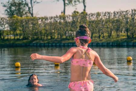 Kinder schwimmen im Wasser am Strand des Ferienparks EuroParcs De Rijp