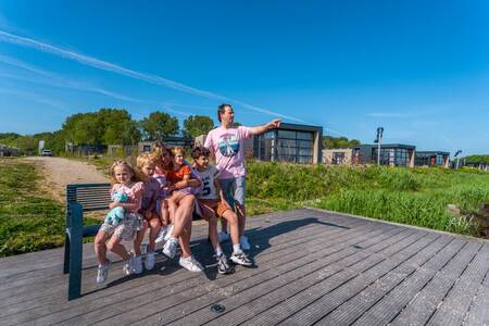 Die Familie sitzt auf einem Steg am IJsselmeer im Ferienpark EuroParcs Enkhuizer Strand