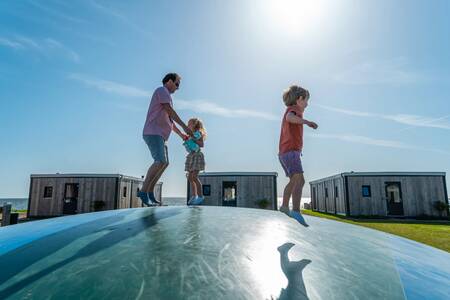 Familie auf dem Lufttrampolin auf einem Spielplatz im Ferienpark EuroParcs Enkhuizer Strand