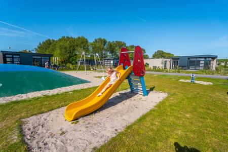 Kind auf der Rutsche auf dem Spielplatz des Ferienparks EuroParcs Enkhuizer Strand