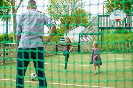 Familie spielt Fußball auf dem multifunktionalen Spielfeld des Ferienparks EuroParcs Gulperberg