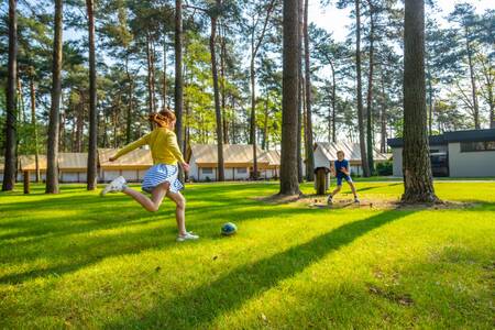 Kinder spielen Fußball vor den Ferienhäusern von EuroParcs Hoge Kempen