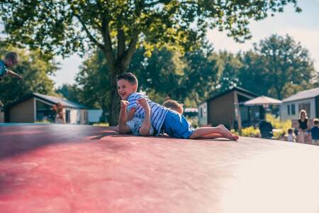 2 Kinder spielen auf dem Lufttrampolin auf dem Spielplatz im Ferienpark EuroParcs Kaatsheuvel