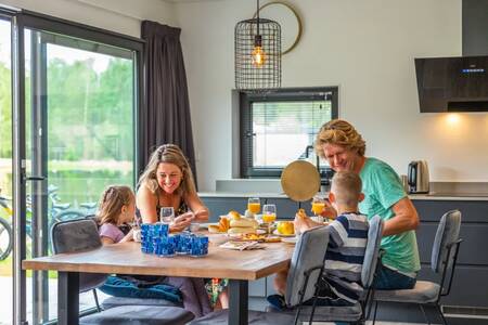 Familie beim Frühstück in der Küche eines Ferienhauses im Ferienpark EuroParcs Maasduinen