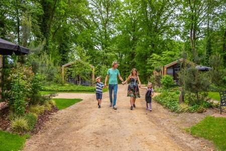 Die Familie geht zwischen den Ferienhäusern im Ferienpark EuroParcs Maasduinen spazieren