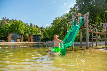 Im Ferienpark EuroParcs Maasduinen spielen Kinder auf Spielgeräten im Wasser