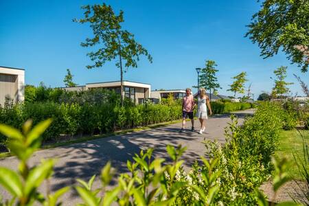 Paar geht vor Ferienhäusern im Ferienpark EuroParcs Marina Strandbad spazieren