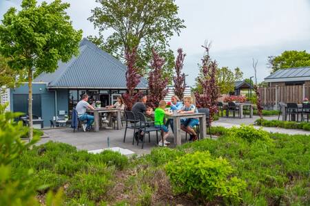 Menschen beim Essen auf der Terrasse der Snackbar im Ferienpark EuroParcs Markermeer