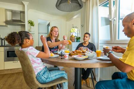 Familie am Tisch in der Küche eines Ferienhauses im Ferienpark EuroParcs Molengroet