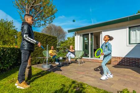 Familie beim Entspannen im Garten eines Ferienhauses im Ferienpark EuroParcs Molengroet