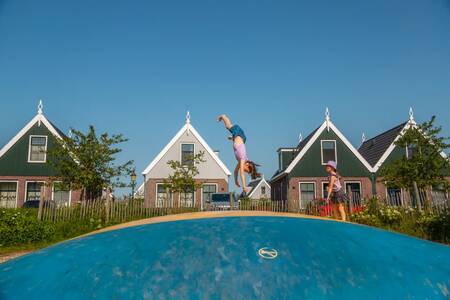 Kinder springen auf dem Lufttrampolin auf einem Spielplatz im EuroParcs Poort van Amsterdam
