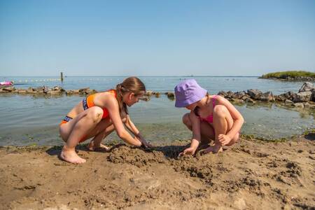 Kinder spielen im Sand am Strand des Ferienparks EuroParcs Poort van Amsterdam