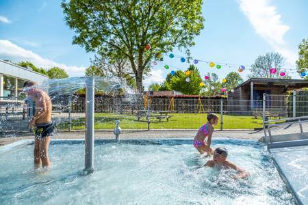 Kinder planschen im Außenpool des Ferienparks EuroParcs Poort van Maastricht