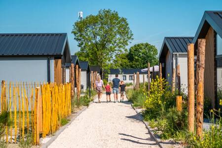 Familienwanderungen auf einem Weg zwischen Ferienhäusern im Ferienpark EuroParcs Poort van Zeeland