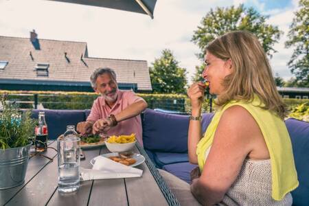 Paar beim Essen auf der Terrasse der Snackbar im Ferienpark EuroParcs Reestervallei