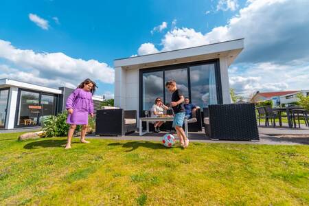 Die Familie entspannt sich im Garten eines Ferienhauses im Ferienpark EuroParcs Veluwemeer