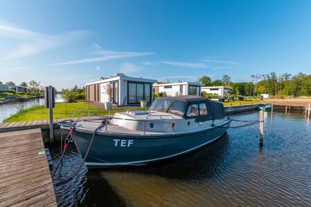 Boot an einem Steg vor einem Ferienhaus im Ferienpark EuroParcs Veluwemeer