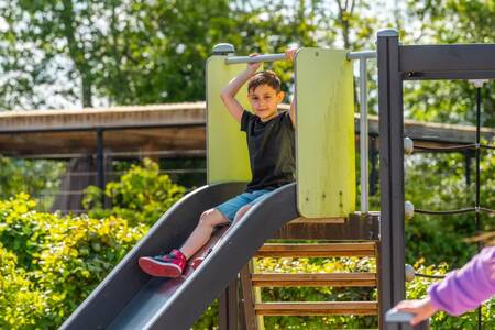 Junge auf der Rutsche auf einem Spielplatz im Ferienpark EuroParcs Veluwemeer